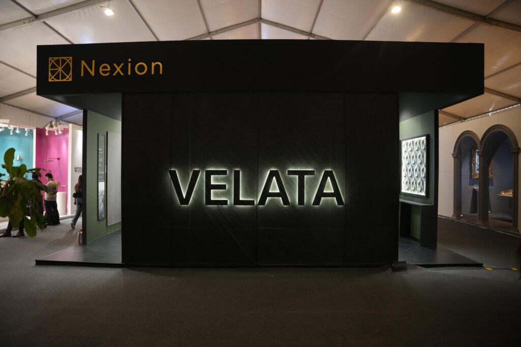 Nexion booth entrance at India Design ID Mumbai 2026 with the Velata collection name prominently displayed in metallic lettering against a dark background. 